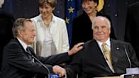 Yhdysvaltain entinen presidentti George Bush ja Saksan entinen liittokansleri Helmut Kohl istuvat ja kättelevät toisiaan Saksojen yhdistymisen vuosijuhlassa 31.10.2009.