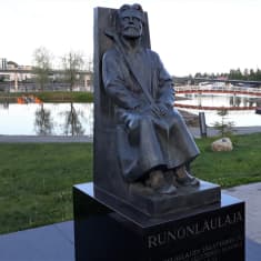 Runonlaulaja Miihkali Arhippaisen patsas muistuttaa runonlaulajien merkityksestä Joensuun Ilosaaressa.
