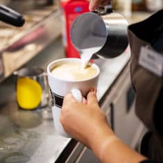 barista kaataa latteen maitoa