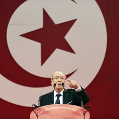87-vuotias veteraanipoliitikko Beji Caid Essebsi pitää puhettaan Tunisian lippu taustalla.