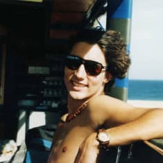 Justin Trudeau kuorma-auton kyydissä Afrikassa, taustalla sininen meri.
