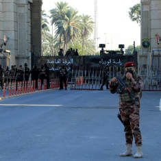 Irakin turvallisuusjoukkojen jäseniä valvomassa tarkasti vartioidun vihreän vyöhykeen porttia Bagdadissa. Kuva otettu 6. marraskuuta 2021.