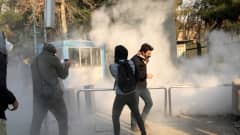 Iranilaisopiskelijat yrittivät suojautua kyynelkaasulta mielenosoituksessa Teheranin yliopistolla lauantaina.
