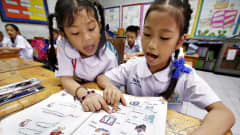 Thaimaalaisia lapsia opiskelemassa englantia ala-asteella Bangkokissa.
