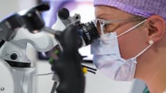 Erikoistuva lääkäri harjoittelee robottimikroskoopin käyttöä