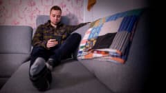 Mika Hartio lukee e-kirjaa sohvalla