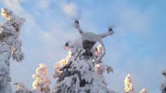 Drone lentää talvista taivasta vasten.