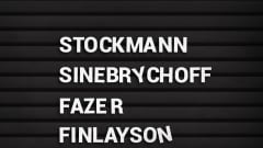 Mustassa nimitaulussa valkoisella nimet: Stockmann, Sinebrychoff, Fazer ja Finlayson.