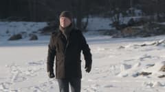 Mies kävelee lumisella rantajäällä.