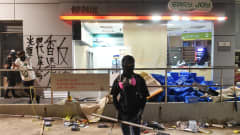 Mielenosoittaja vandalisoidun liiketilan edessä Kowloon Tongin alueella Hongkongissa 14. marraskuuta.