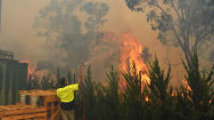 Työntekijä sammutti paloa Queanbeyanissa, Canberran lähellä Australaissa torstaina.