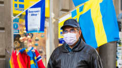 Hengityssuojaan pukeutunut mies kävelee kadulla Tukholmassa.