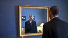 Barac Obama katsoo peiliin hetkeä ennen kuin valan vannomista 2009.