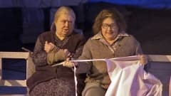 Kaksi vanhaa naista istuu penkillä näyttämöllä