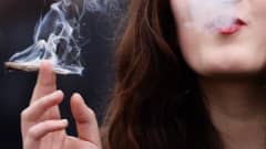 Nuori nainen polttaa kannabissätkää.