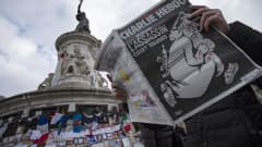 Ranskalaisesen Charlie Hebdo -lehden keskiviikkona ilmeestyneen erikoisnumeron kannessa on esitettynä Jumala, jolla on verta käsissä ja rynnäkkökivääri selässä.