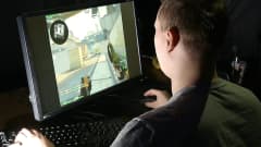 Mies pelaa tietokoneella Counter-Strike -peliä
