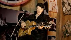 Elvis-nukke soittaa kitaraa ja laulaa.