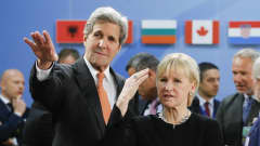 John Kerry ja Margot Wallström katsovat ohi kameran Kerryn käden osoittamaan suuntaan.