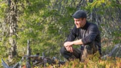 Juha-Pekka Paananen katselee metsässä kuukkelia.