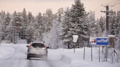 Auto liikenteessä lumisessa maisemassa Muoniossa.