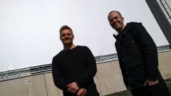 Antti Juntunen ja Henry Erkkilä virittävät valkokankaan teollisuushallin seinään.