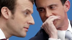 Valls kuiskaa kätensä suojasta jotain Macronille