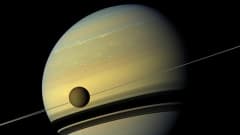 Titan-kuu Saturnuksen kiertoradalla. Kuvassa näkyy myös Saturnuksen renkaita. 