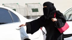 Nainen avaa auton ovea Saudi-Arabiassa.