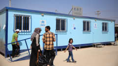 Ihmisiä YK:n pakolaisjärjestö UNHCR:n toimipisteen edessä Zaatarin pakolaisleirillä. 