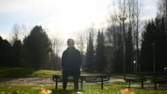 Asperger-diagnoosin saanut Anne istuu puiston penkilllä.