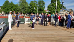 Presidenttipari seisoo Naantalissa laiturilla kuuntelemassa kaupungin tervehdystä.