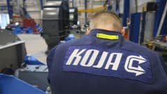 KOJA:n logo työntekijän selässä
