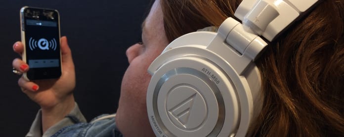 Nainen kuuntelee kännykästä podcastia.