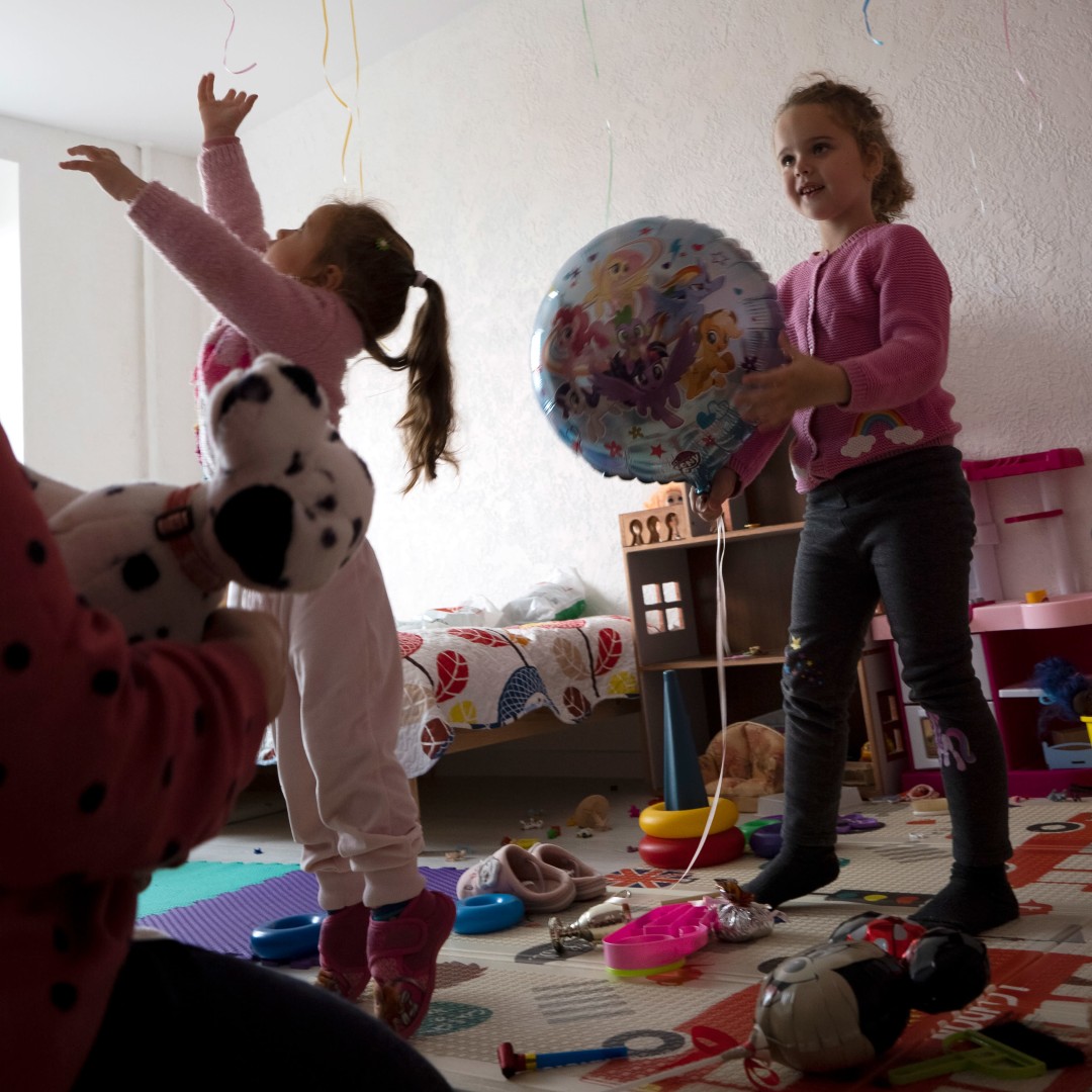 Kaksi tyttöä leikkii ilmapalloilla.
