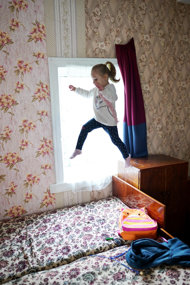 Alina hyppää sängylle kotonaan.