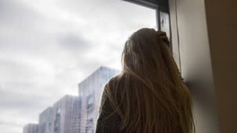 Tyttö katselee ikkunasta ulos