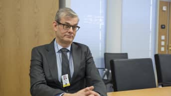 Pasi Tuominen ulkoasiainministeriöstä istuu pöydän ääressä.
