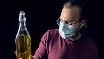 Eero Mäntymaa pitää kädessään oliiviöljypulloa