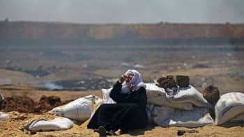 Palestiinalaisnainen suojaa hengitysteitään Israelin joukkojen kyynelkaasulta.
