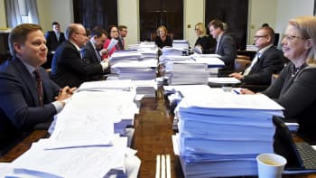 Perustuslakivaliokunta kokoontuneena suurien paperipinojen äärelle.