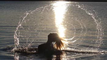 Nainen nousee järvestä