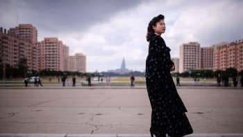 Perinteiseen asuun pukeutunut pohjoiskorealainen opas odottaa turisteja Pyongyangissa. 