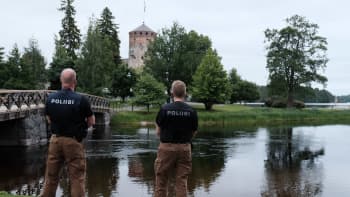 Kaksi poliisia vartioi Olavinlinnaa.