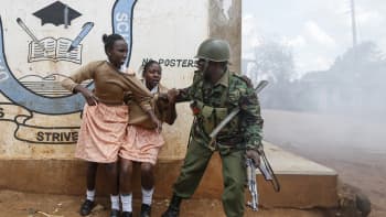 Poliisi yritti saada koulutytöt pois levottomuuksien ja kyynelkaasun keskeltä Nairobin Kawangwaren slummissa, Keniassa 30. lokakuuta. Vaalit ovat aiheuttaneet levottomuuksia eri puolilla maata.