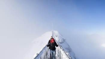 Kaksi turistia ylittävät riippusiltaa Col du Pillonissa Sveitsissä 20. joulukuuta. 