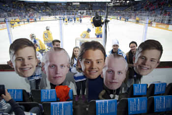 Fanit pitävät käsissään valtavia pahvipäitä
