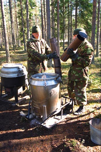 Varusmiehet kokoavat kenttäkeittiön piippua.