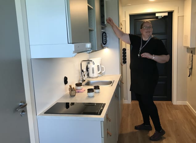 Hotelliyrittäjä Helena Puhakka-Tarvainen avaa keittiön kaappia huoneistohotelli Lietsun huoneessa Joensuussa.