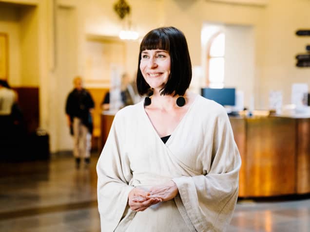 Intendentti Liisa Lohtander seisoo Suomen kansallismuseon aulassa.